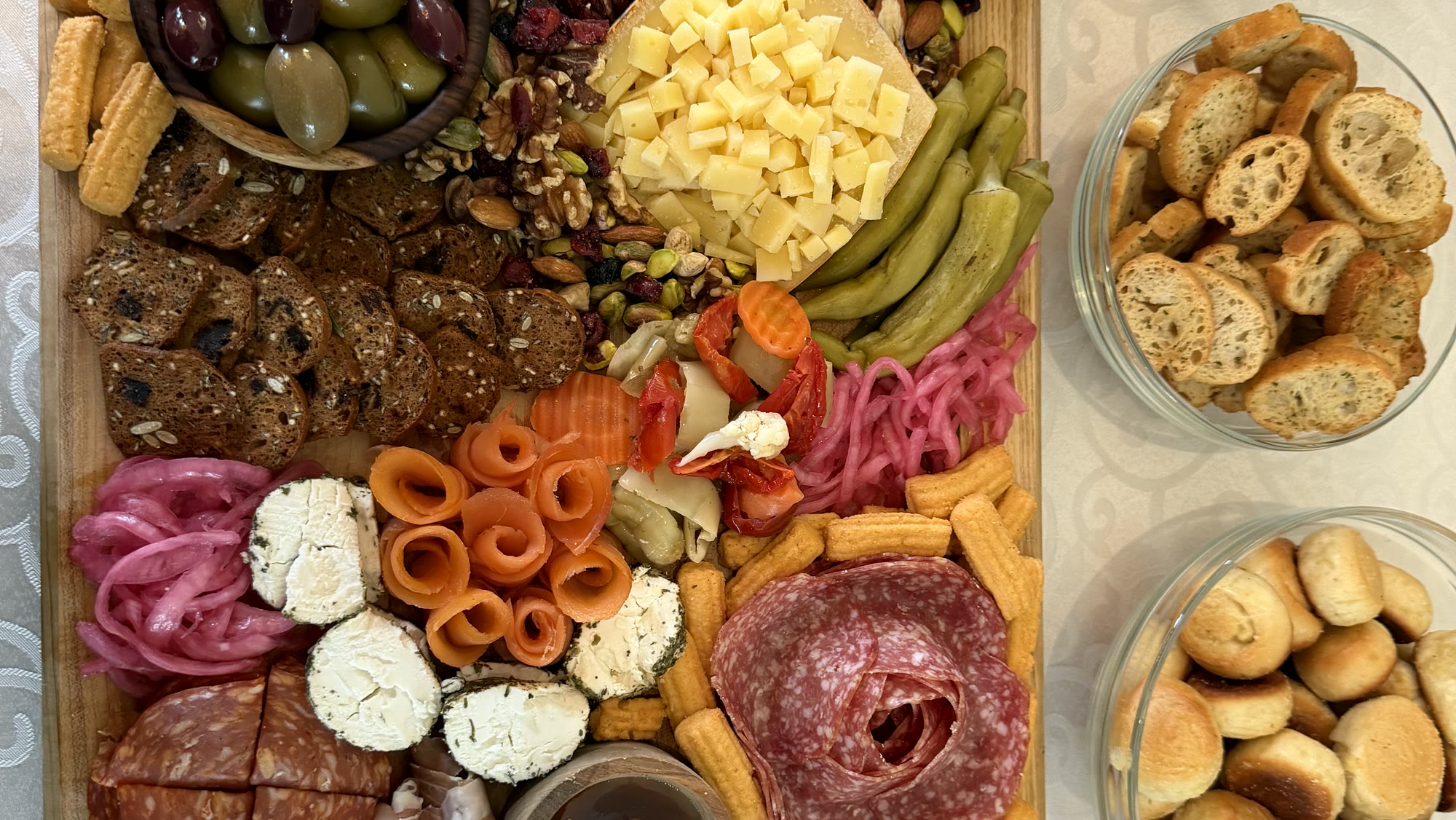 A Charlie B's grazing board: salami, prosciutto, cheeses, olives, pickled vegetables, crostini, and rolls